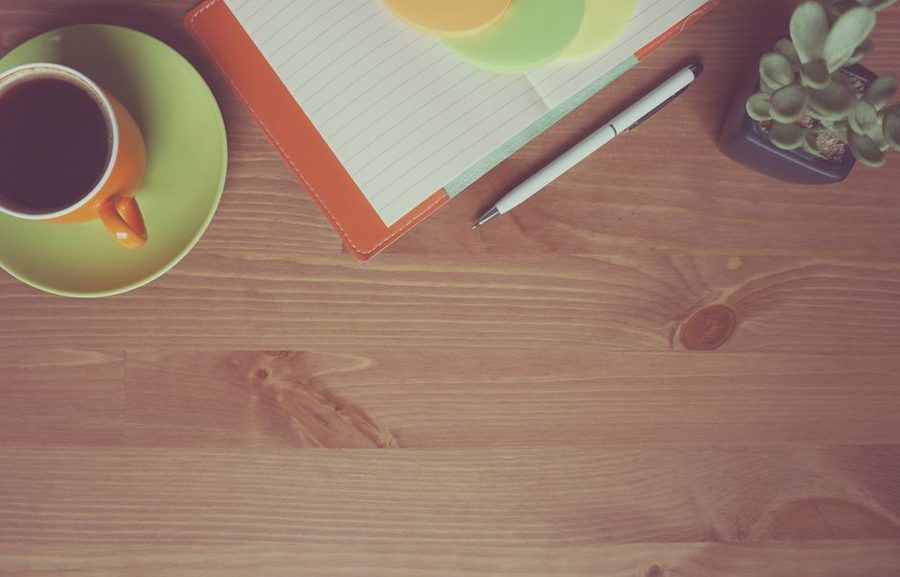 A notebook and pen on a wooden desk