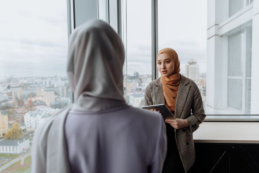 Two colleagues talking beside a window